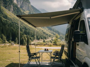 캠핑카 측면에 설치된 어닝 아래 야외 테이블과 의자